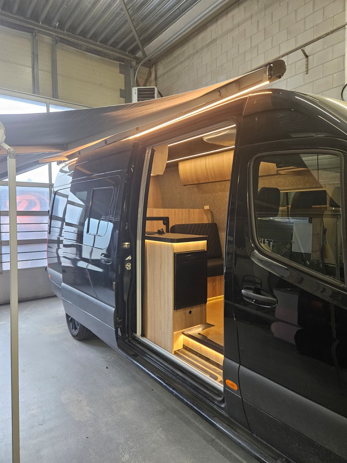 Schwarzer Mercedes Sprinter Camper mit Markise von R-Line Maatwerk